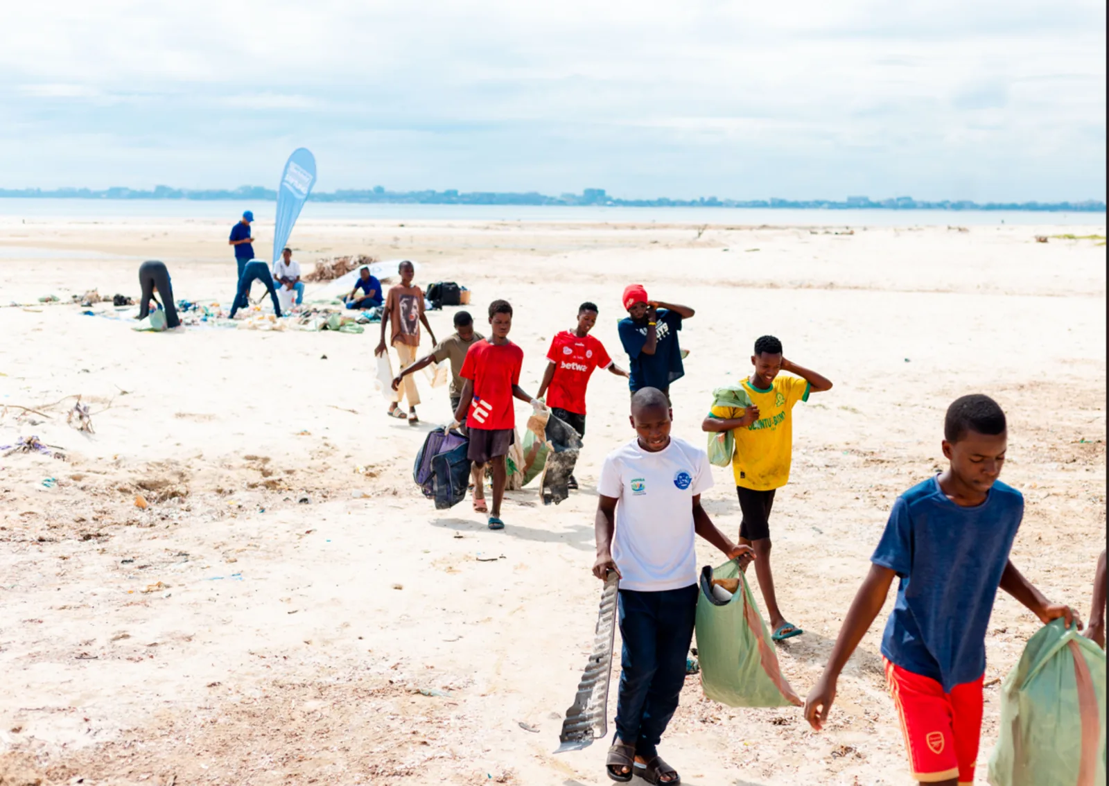 Vijana wakibeba mifuko ya taka baada ya clean-up